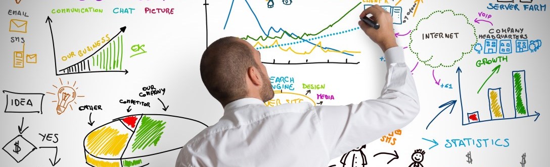 Man professionally dressed writing on white board