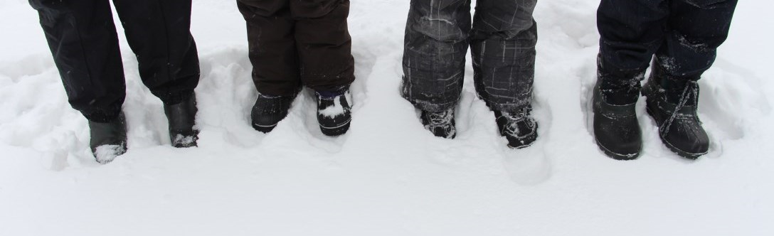 Image of 4 people's feet in the snow