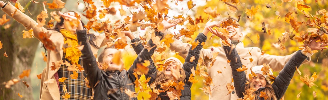 Image of family playing with fall leaves