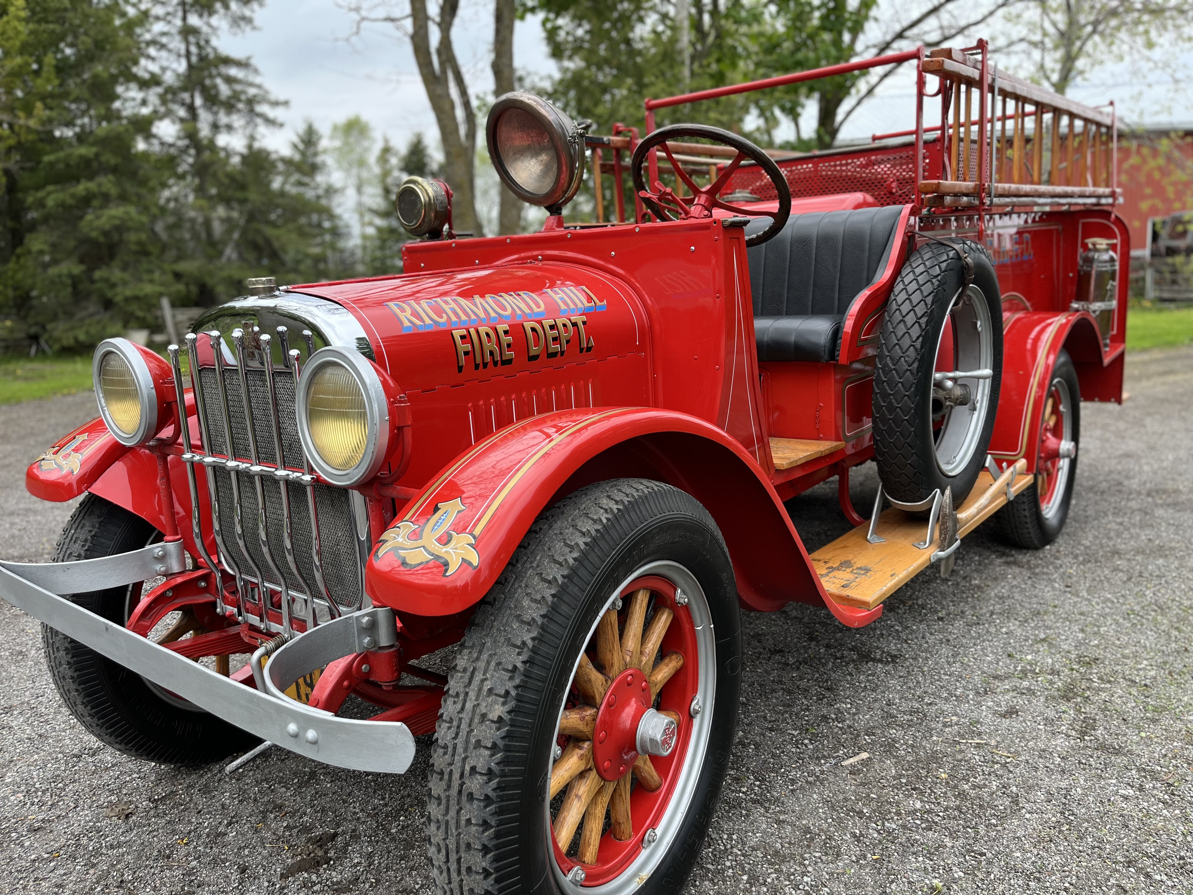 antique fire truck in foreground, with greenery behind