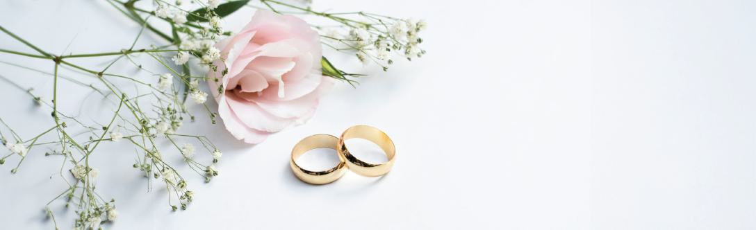 rose and baby's breath flowers around two wedding bands